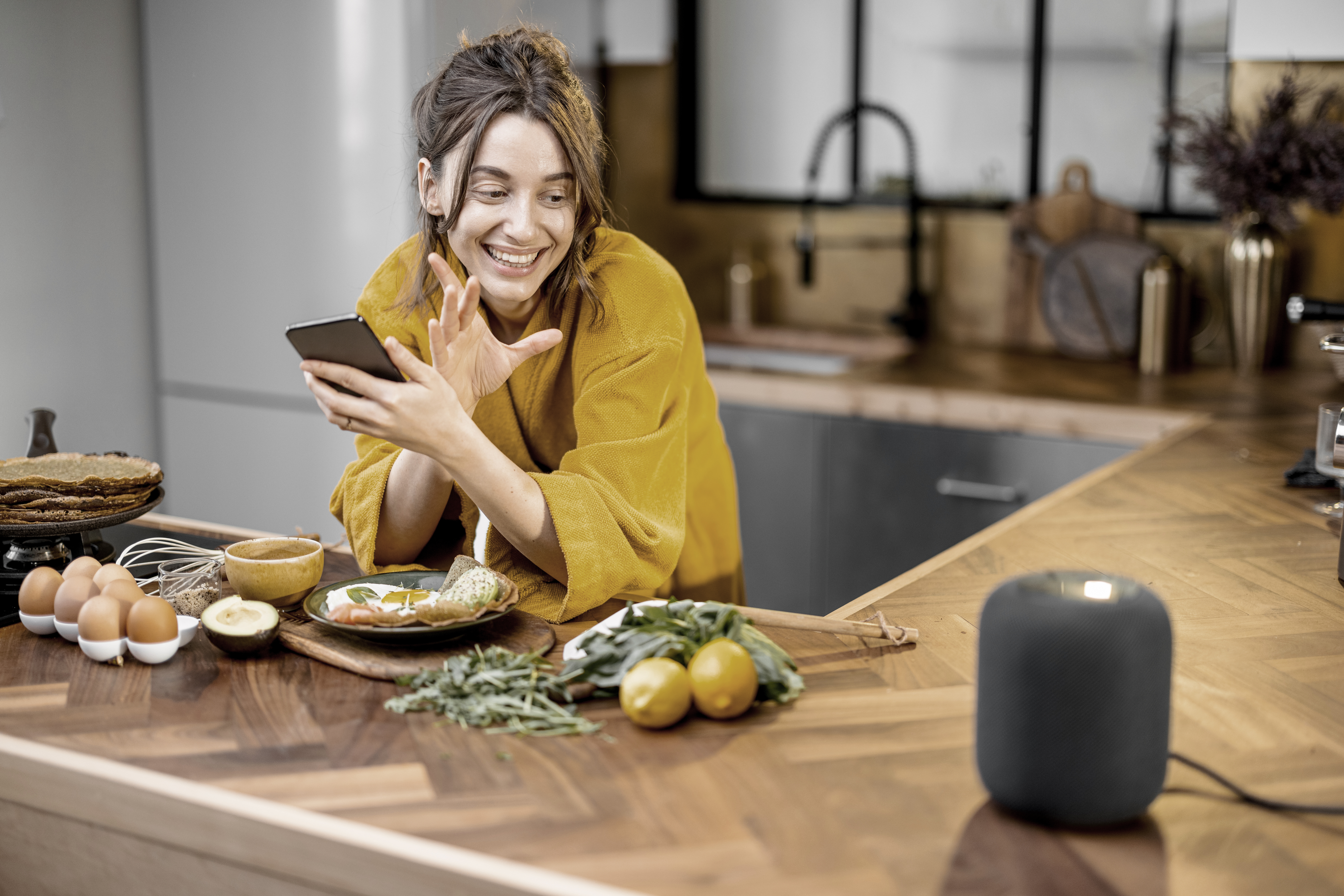 Woman speaking to a smart speaker during a breakfast at home Woman speaking to a smart speaker during a breakfast at home
